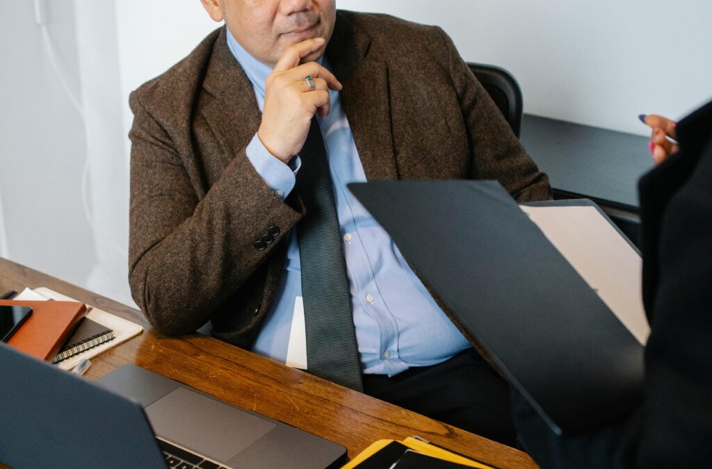 Business professionals engaged in a formal meeting indoors, discussing documents.