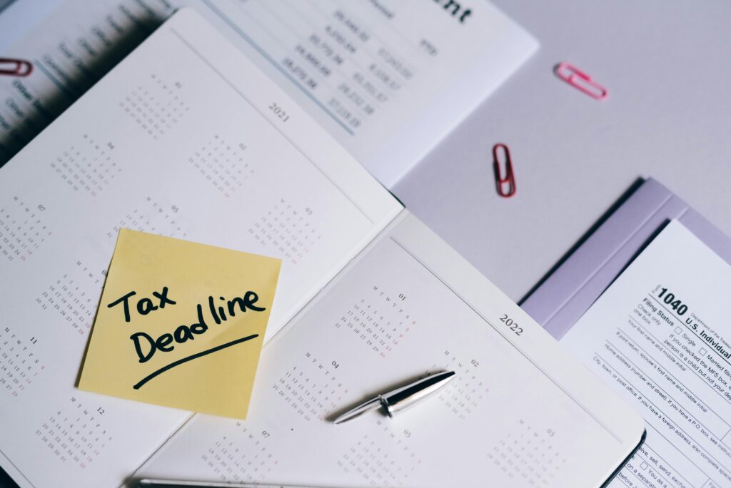 A calendar with a tax deadline note and tax forms, emphasizing organization.